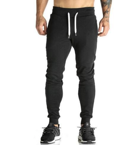 Black jogger pants worn by a person on a white background