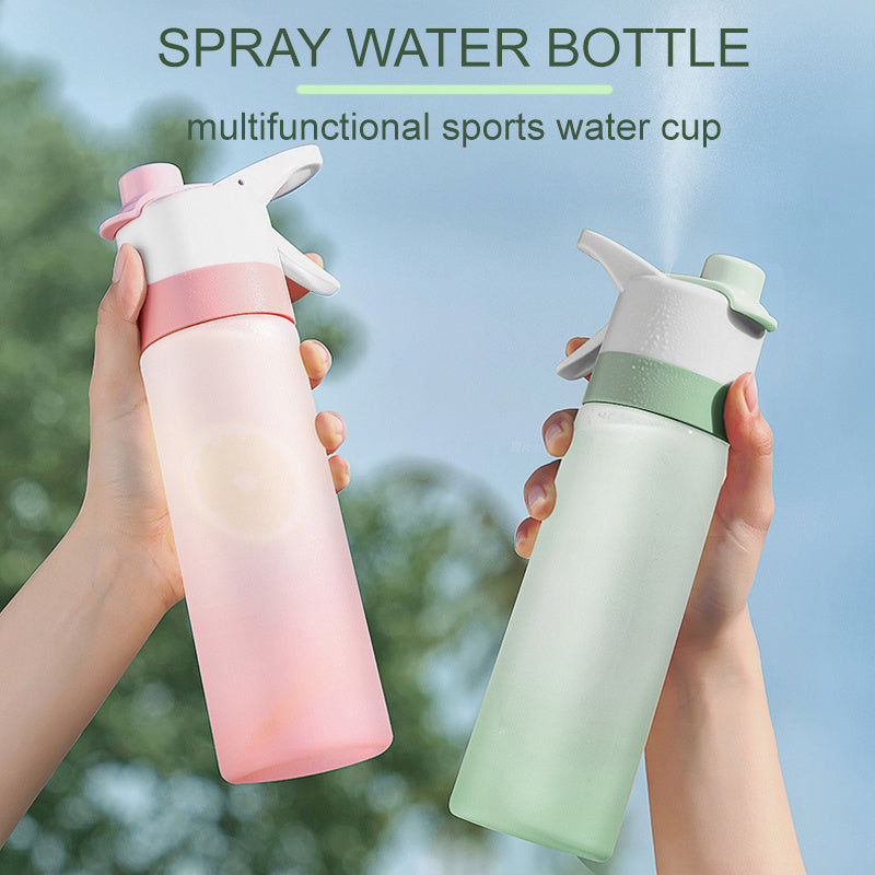 Two spray water bottles held by hands with a blurred green outdoor background.