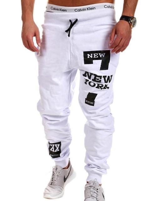 White jogger pants with black text and logos on a white background