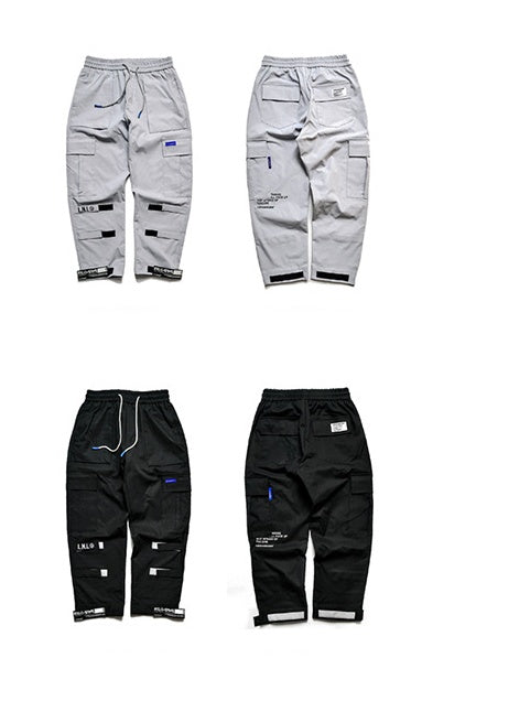 Two pairs of gray pants and two pairs of black pants on a white background