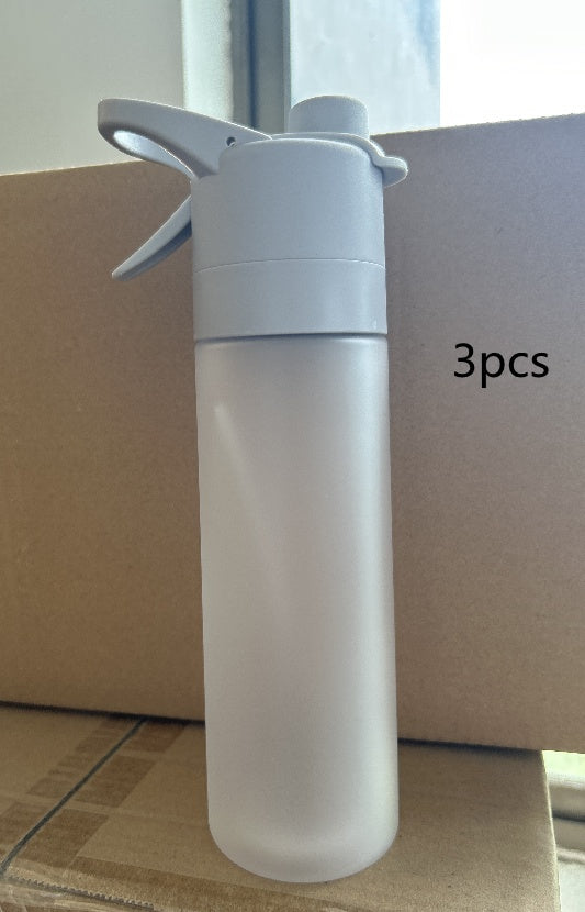 Clear spray bottle with white nozzle on a cardboard surface