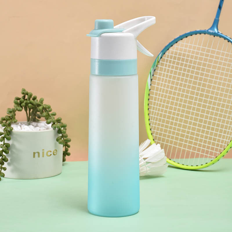 Gradient water bottle with a plant and vintage racket on a green surface