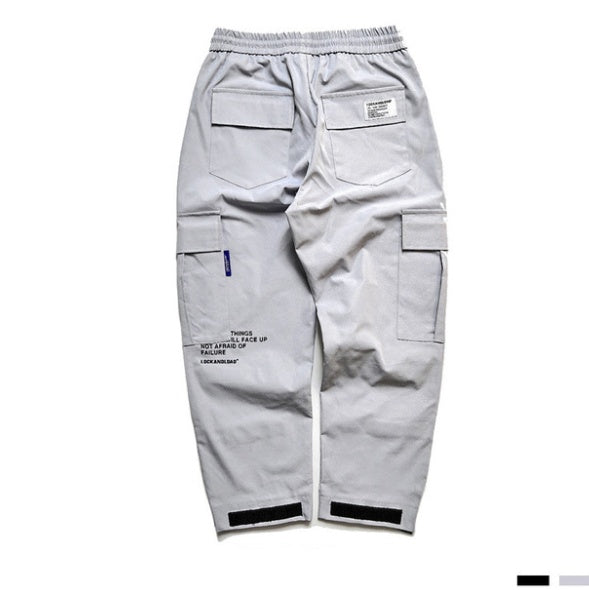 Light gray cargo pants with multiple pockets on a white background