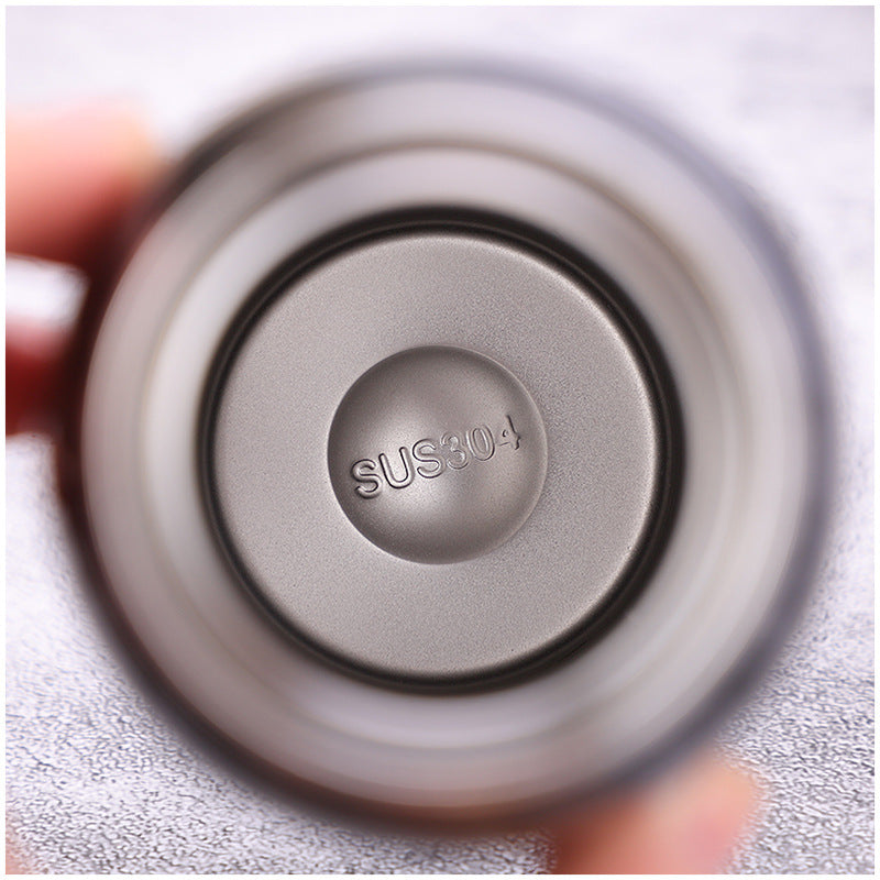 Metallic component with 'SUS304' marking held by a hand against a light background