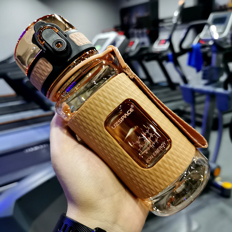 Person holding a UZSPACE branded water bottle in a gym setting