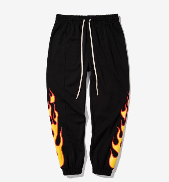 Black sweatpants with flame designs on a white background