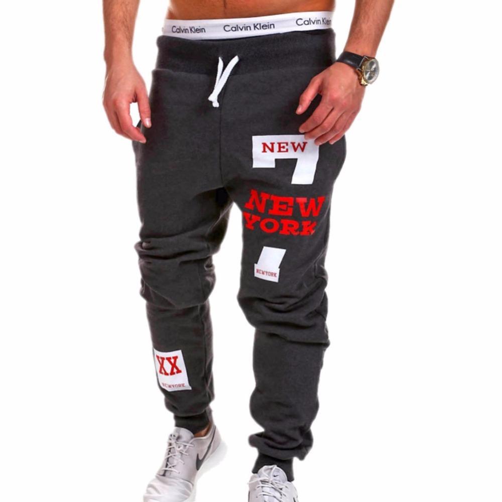 Dark gray sweatpants with 'New York' text and patches on a white background