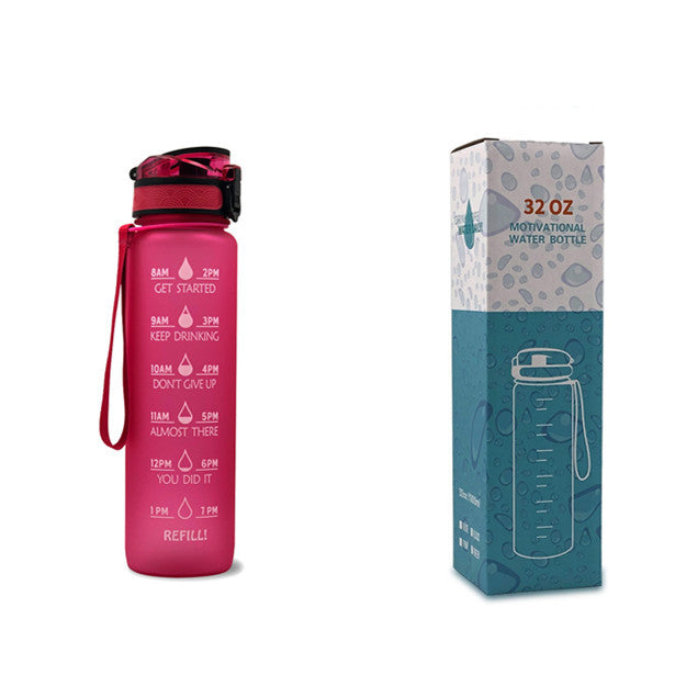 Pink water bottle with motivational text and red cap next to its packaging on a white background