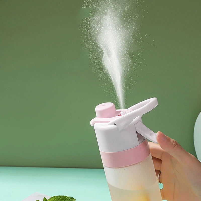 Pink and white spray bottle being used with a green background